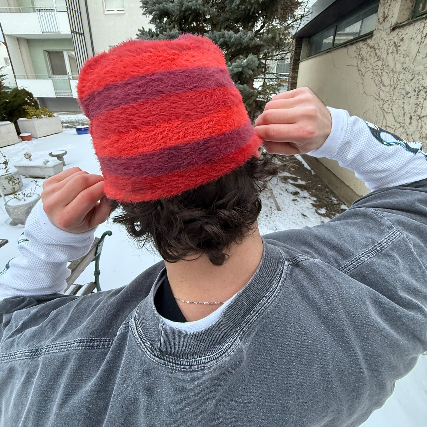 
                  
                    Close-up of the back of a red comfy beanie showing the hairy fabric texture.
                  
                